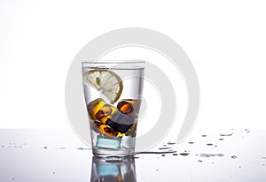 Glass with ice and water splashes