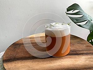 A glass of iced milk tea on wood plate