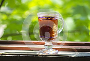 Glass of Irish coffee on beautiful green natural background.