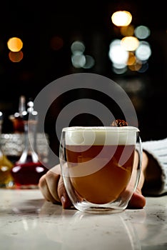 Glass of irish coffee on a table. classic irish coffee saved on a dark bar with a float of heavy cream