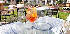 A glass of Italian cocktail Spritz stands on a glass table