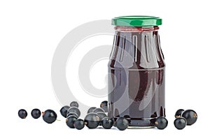 Glass jar with black currants jam and some berries near
