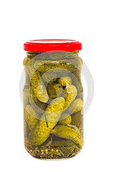 Glass jar canned cucumbers on white
