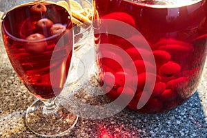 The glass jar of cherry compote, a glass with compote, sweets in a vase, close up