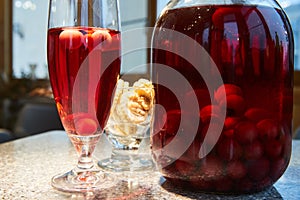 The glass jar of cherry compote, a glass with compote, sweets in a vase, close up