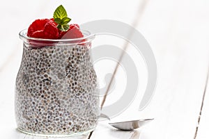 Glass jar of chia pudding with raspberry