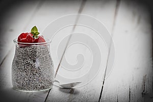 Glass jar of chia pudding with raspberry