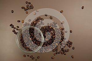 Glass jar with coffee and coffee beans scattered on the table
