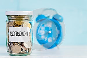 Glass jar coins with alarm clock background for retirement