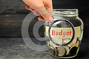 Glass jar with coins and the inscription `Budget`. The concept of accumulating money in the family budget. Family Insurance. Distr