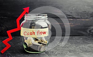 Glass jar with coins and the inscription ` Cash flow ` and up arrow. Financial concept. Investments and growth of assets, retireme