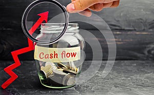 Glass jar with coins and the inscription ` Cash flow ` and up arrow. Financial concept. Investments and growth of assets, retireme