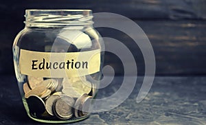 Glass jar with coins and the inscription `Education`. The concept of education for yourself or children. Accumulation of money for