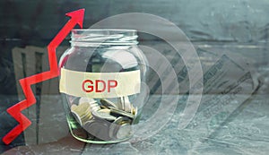 Glass jar with coins and the inscription ` GDP ` and up arrow. Business, economic, finance, salary, crisis. Economic growth concep