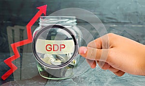 Glass jar with coins and the inscription ` GDP ` and up arrow. Business, economic, finance, salary, crisis. Economic growth concep