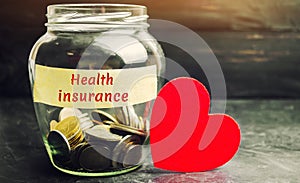 Glass jar with coins and the inscription `Health Insurance`. The concept of medical insurance of life, family, health. Healthcare.