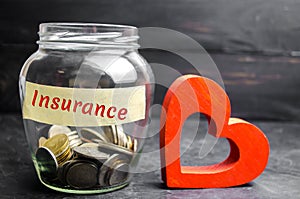 Glass jar with coins and the inscription `Insurance`. The concept of medical insurance of life, family, health. Healthcare. Red he