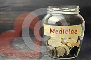 Glass jar with coins and the inscription `Medicine`. The concept of family medicine insurance, healthcare. Medical expenses. Distr