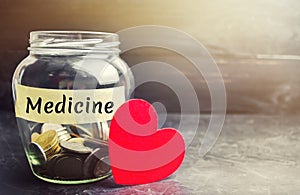 Glass jar with coins and the inscription `Medicine`. The concept of family medicine insurance, healthcare. Medical expenses. Distr