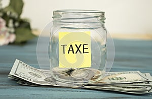glass jar with coins standing on the money. Tax concept
