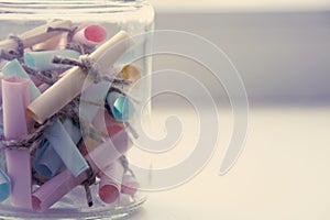 Glass jar with colored notes with blur