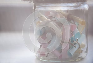 Glass jar with colored notes with blur and toning.