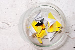 A glass jar with colored notes of craft paper. Airplanes of different colors. Light background.