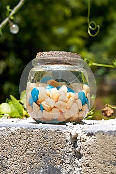 A glass jar with colored stones