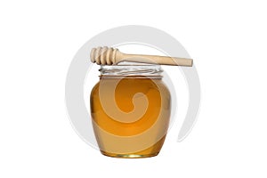 Glass jar with delicious fresh honey. There is a wooden ladle nearby. White isolated background.