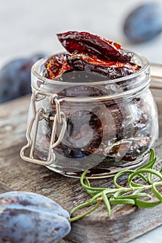 Glass jar with dried plums close-up.