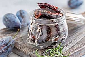 Glass jar with dried plums close-up.