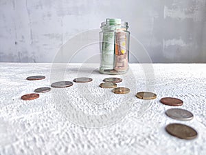 Glass Jar Filled With Euro Banknotes and Coins on Table. Concept of savings ranging from small money to large