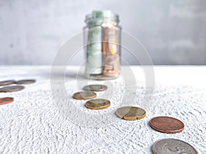 Glass Jar Filled With Euro Banknotes and Coins on Table. Concept of savings ranging from small money to large