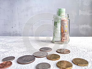 Glass Jar Filled With Euro Banknotes and Coins on Table. Concept of savings ranging from small money to large