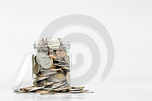 Glass jar full of coins, with copy space on white background