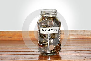 A glass jar full of coins to represents donation