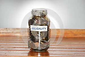 A glass jar full of coins to represents frugality photo