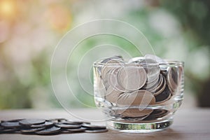 A glass jar with full of coins on wooden table, step for future, saving money, home, loan, education