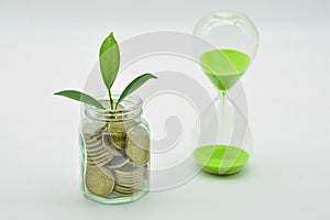 Glass jar full of coins and an hourglass photo