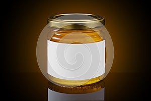 Glass jar full of honey with white label on dark background