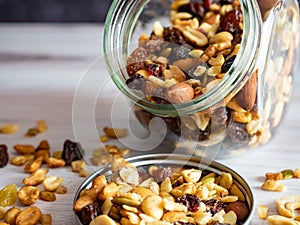 A Glass Jar Full of Nuts, Seeds and Dried Fruits Spilling Out Onto the Lid and the Wooden Counter, Healthy Carbs and Good Fats!