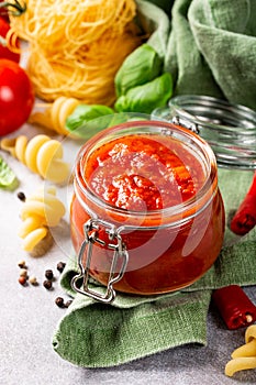 Glass jar with homemade classic spicy tomato pasta or pizza sauce.