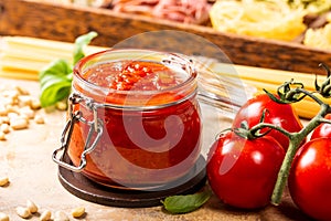 Glass jar with homemade classic spicy tomato pasta or pizza sauce.