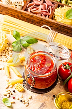 Glass jar with homemade classic spicy tomato pasta or pizza sauce.