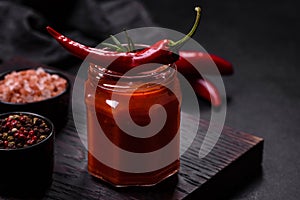 Glass jar with homemade classic spicy tomato pasta or pizza sauce with spices and herbs