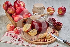 Glass jar of homemade jam from lingonberries and  red apples. Still life with fresh fruit and berries on light wooden table