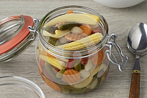 Glass jar with homemade pickled vegetable mix close up