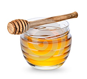 Glass jar with honey and honey dipper isolated on white background