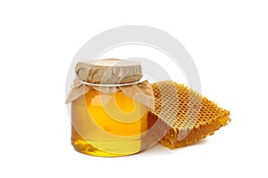 Glass jar of honey and honeycomb isolated on white