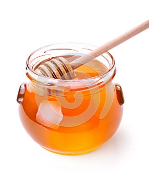 Glass jar of honey with wooden drizzler